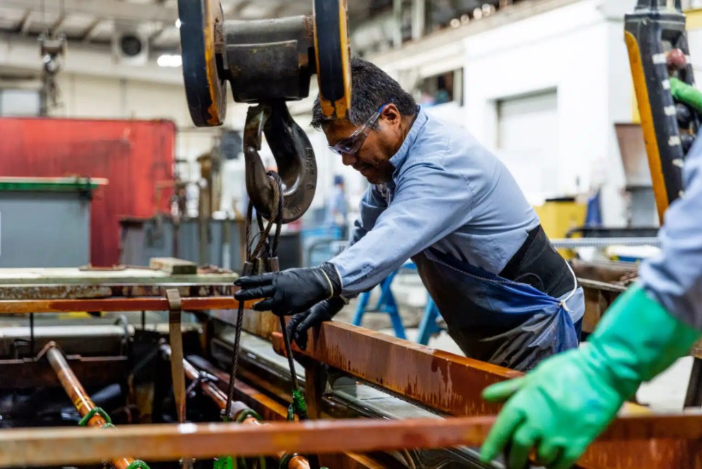 Technician operating electroplating line at a metal finishing plant