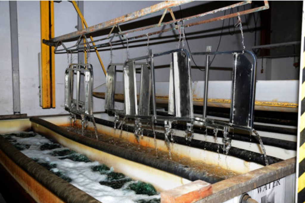Rack electroplating line with parts lifted from treatment tanks